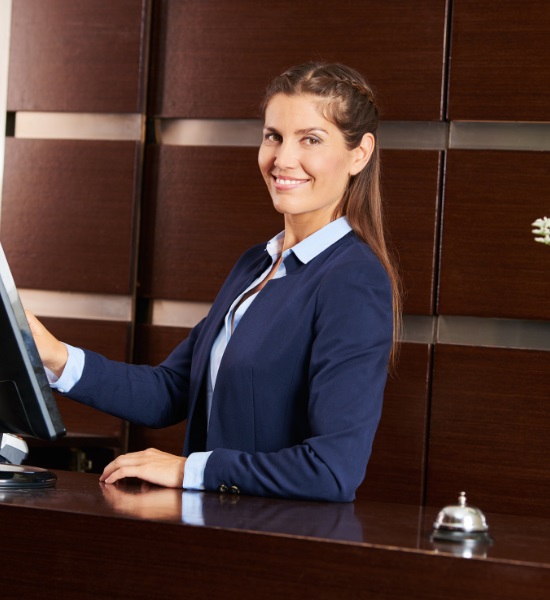 A woman standing at a desk and smiling