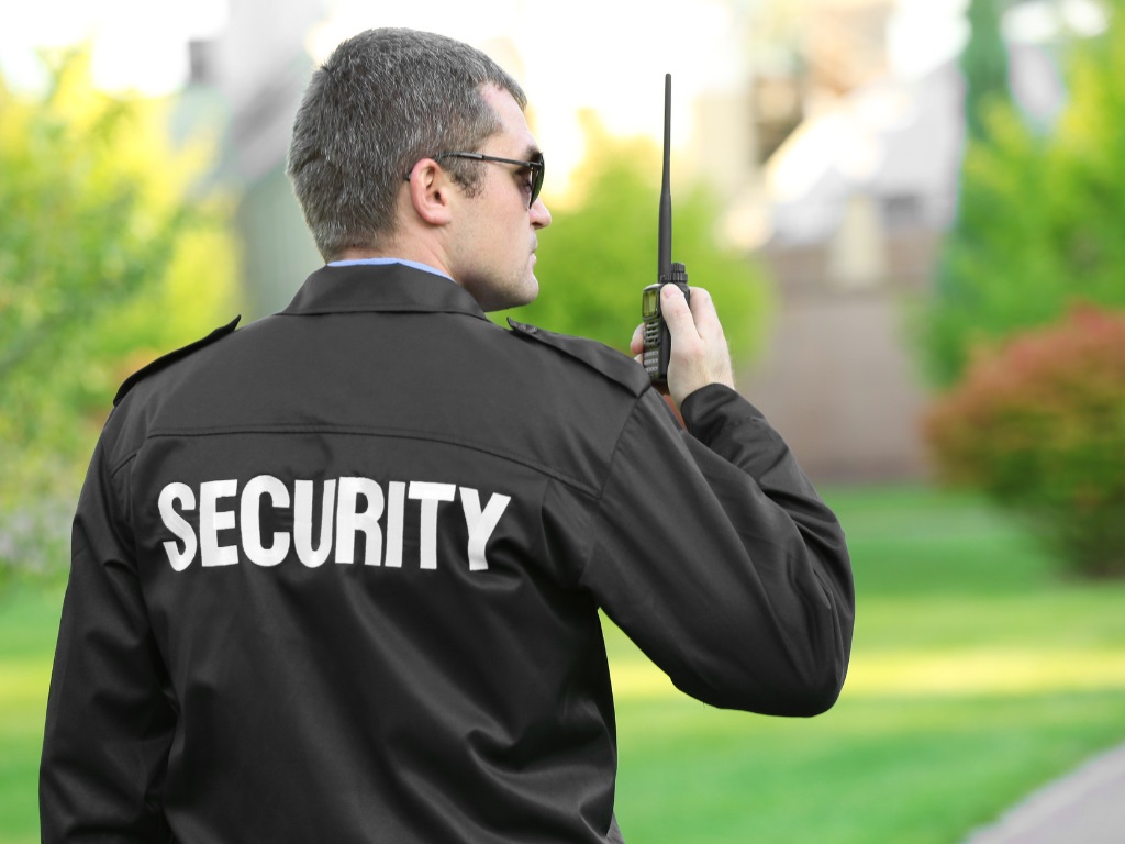 Man in security jacket holding a radio